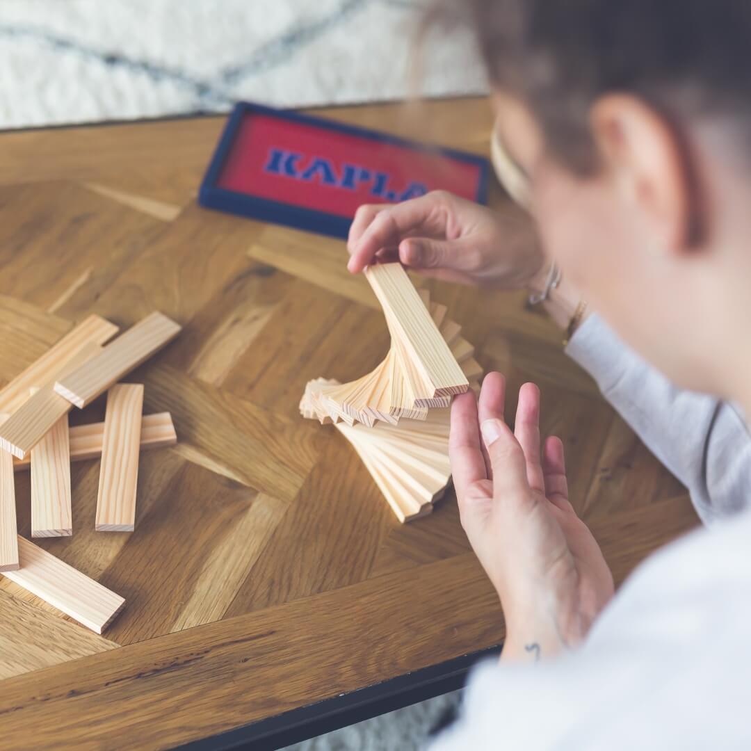 Adult enjoying mindful construction play with KAPLA wooden building planks from Wooden Playroom in Australia