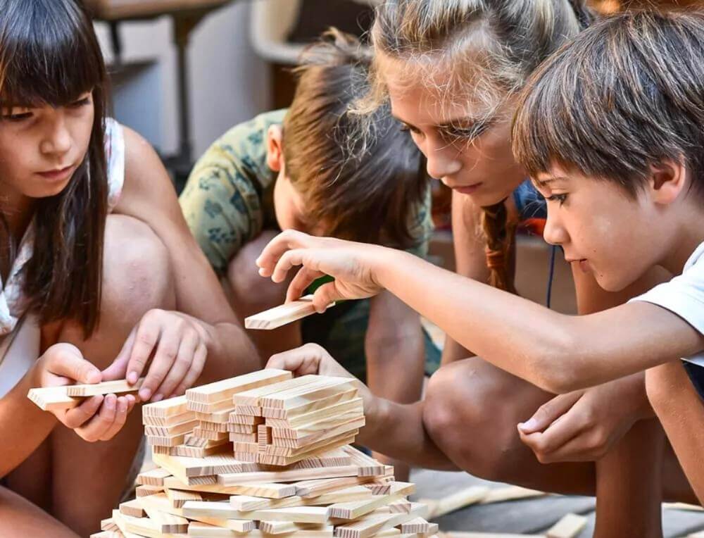 Children playing together in a classroom setting with KAPLA wooden building planks at Wooden Playroom in Australia 