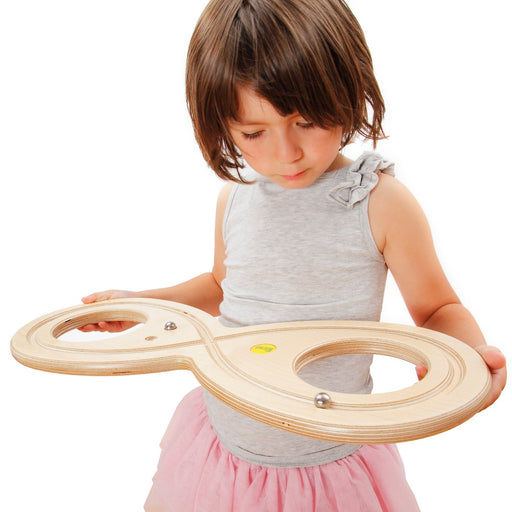 Girl concentrating and using the Erzi 45409 Erzi Wooden Lazy Eight Board for tracking the Figure 8 for adults and children