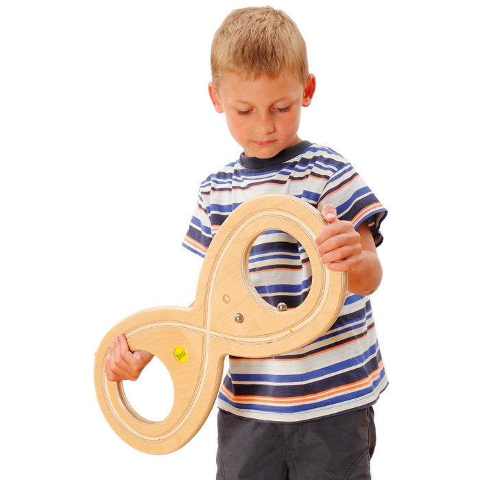 Boy concentrating and using the inner rim of the Erzi Wooden Lazy Eight Board for tracking the Figure 8 for adults and children