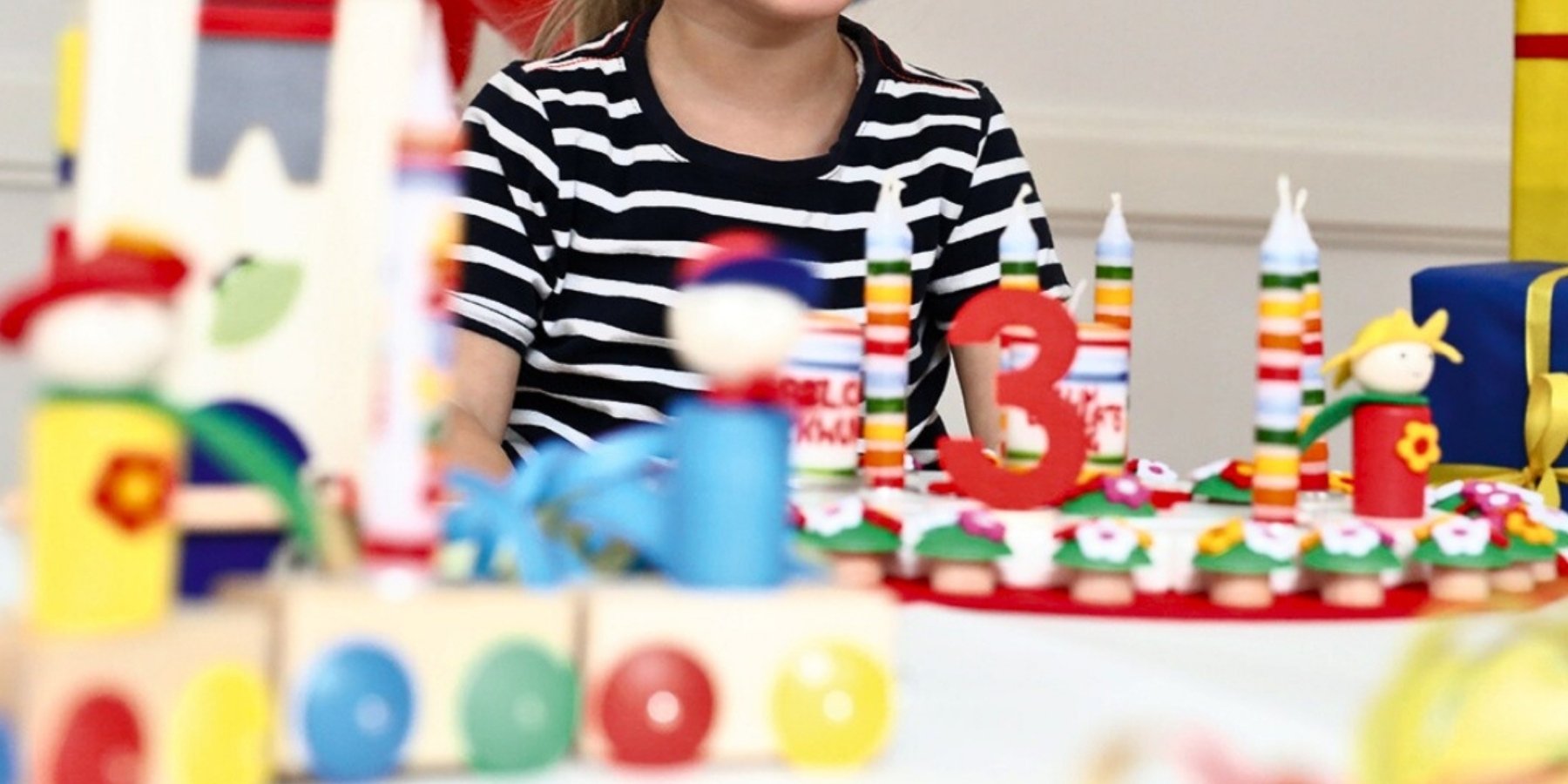 Child with birthday celebration ring and Ahrens candles in a colourful setting