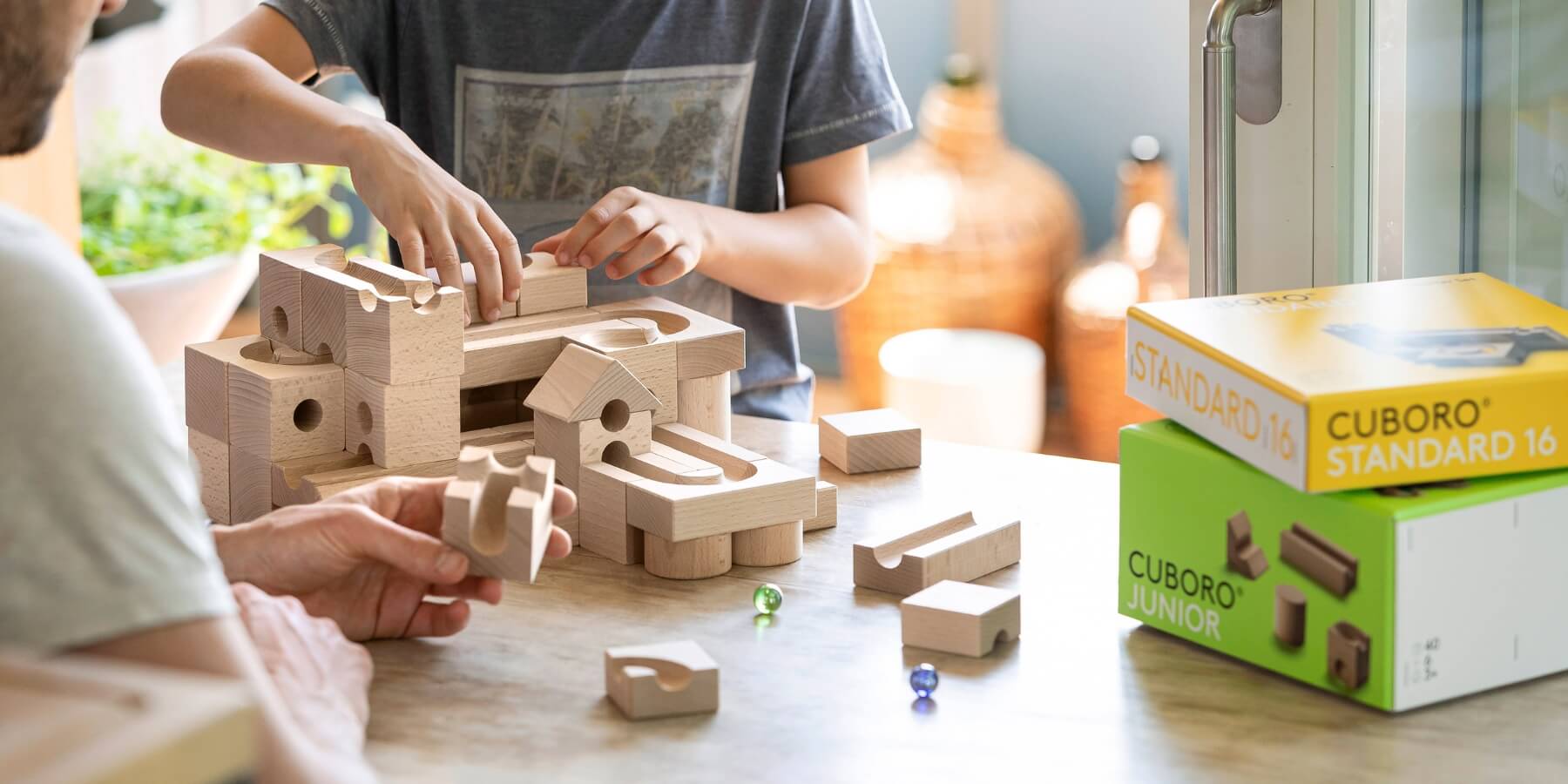 Child and father playing with CUBORO® marble run set