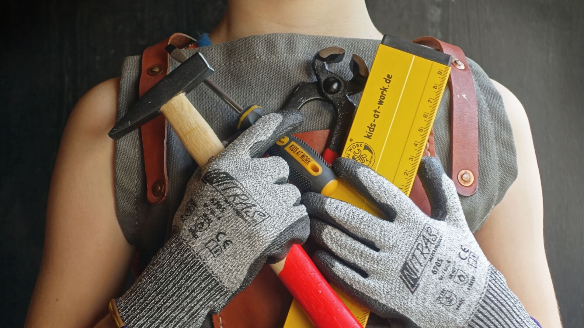 Child holding woodwork and DIY tools from Kids at Work